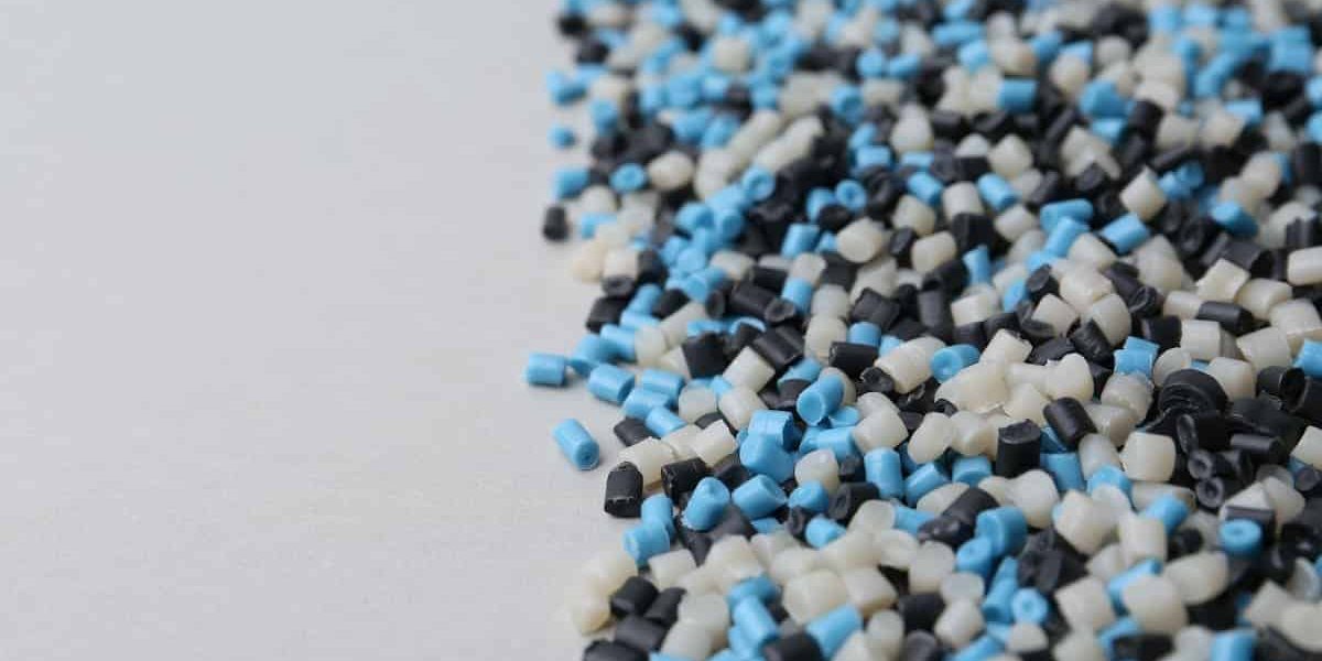 Elastómeros termoplásticos - Pila de gránulos de plástico de colores sobre fondo gris, primer plano.